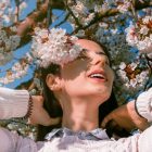 Woman relaxing under blooming cherry blossom tree